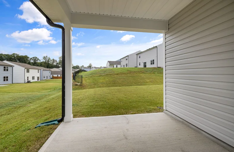 A concrete backyard patio beside a green lawn